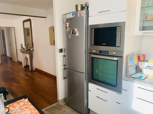 une cuisine avec un réfrigérateur en acier inoxydable et un micro-ondes dans l'établissement Spacious Apartment Paris, à Chelles