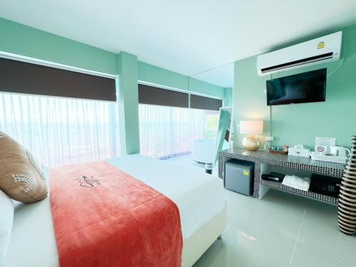 a bedroom with a large bed and a television at Baan Sailboat Beach Kohlarn in Ko Larn