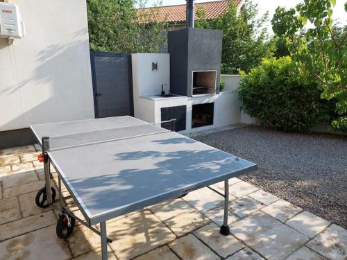 a ping pong table in a backyard with a stove at Villa Martina Bellevue in Šmrika