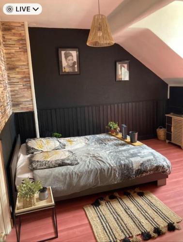 - une chambre avec un lit et un mur noir dans l'établissement Center house with swimming pool, à Brive-la-Gaillarde