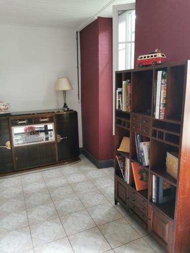 un salon avec des étagères et un mur rouge dans l'établissement Vintagesuitehome, à Arvert