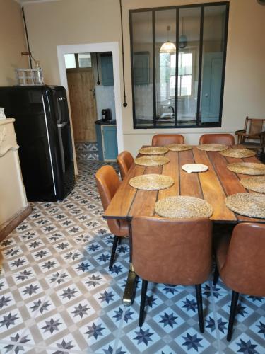 Cette chambre comprend une grande table et des chaises en bois. dans l'établissement Vintagesuitehome, à Arvert