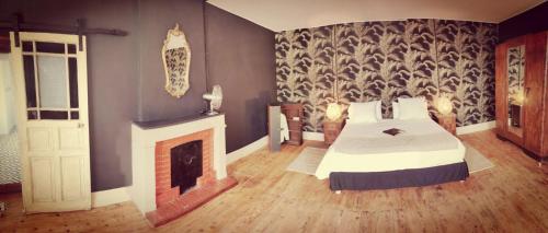 une chambre avec un lit et une cheminée dans l'établissement Vintagesuitehome, à Arvert