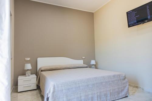 a bedroom with a bed and a tv on the wall at B&B Victoria in Laurenzana