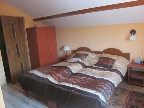 a bedroom with a large bed with a wooden headboard at Pokoje u Eli in Solec-Zdrój