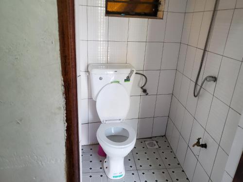 a bathroom with a white toilet in a stall at First Mayor' Garden in Malamagambo