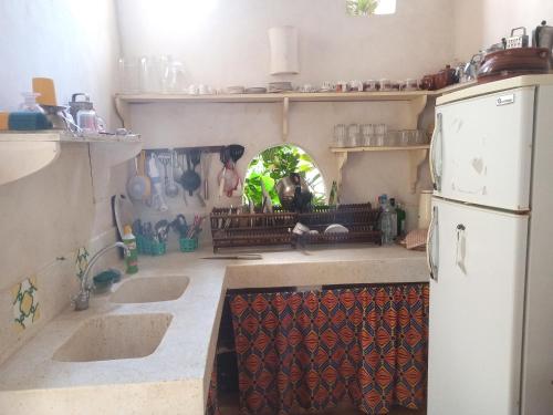 een keuken met 2 wastafels en een koelkast bij Madakani House in Lamu