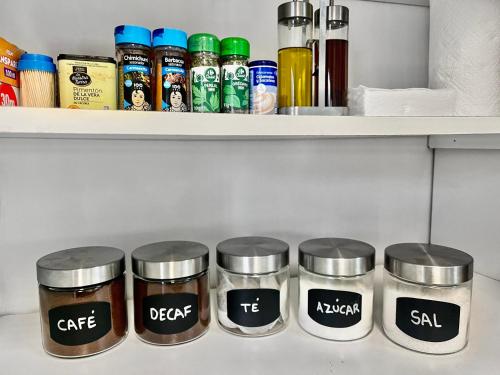 a shelf with four jars of spices at Villa San Patricio I Piscina Privada I Jacuzzi Spa I BBQ I PS5 I Aire Acon I 3000m2 I 5min-Centro in Jerez de la Frontera