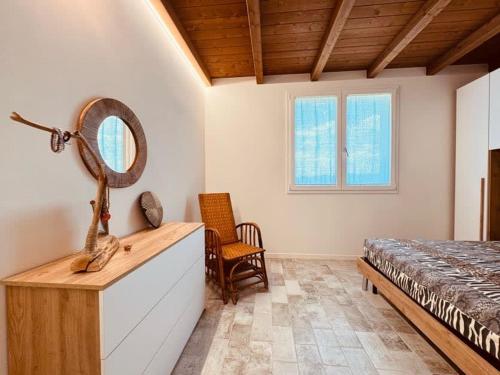 a bedroom with a bed and a mirror and a dresser at Villa Pallegorie in Monte San Pietro