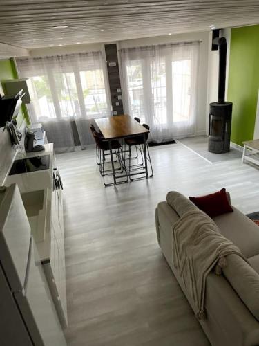 un salon avec un canapé et une table dans l'établissement Maison au coeur du village, à Macornay