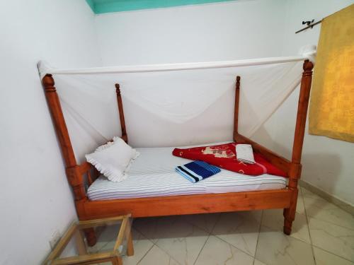 a small bed in a room with a white wall at First Mayor' Garden in Malamagambo
