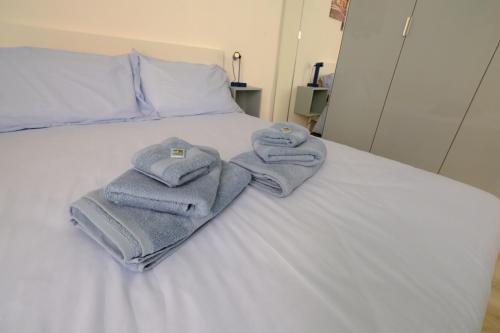 two towels sitting on top of a white bed at Casa Maggiolino by PortofinoVacanze in Rapallo