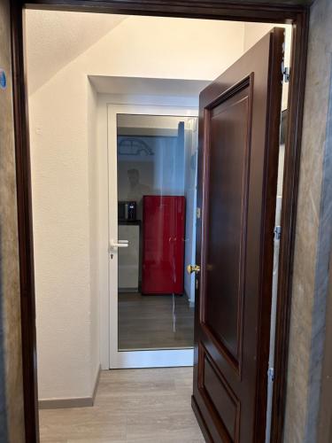 an open door to a kitchen with a red refrigerator at Casa Maggiolino by PortofinoVacanze in Rapallo