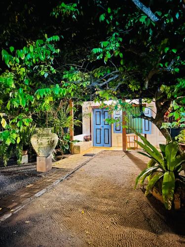 a house with a blue door in a garden at Krishan Villa in Negombo