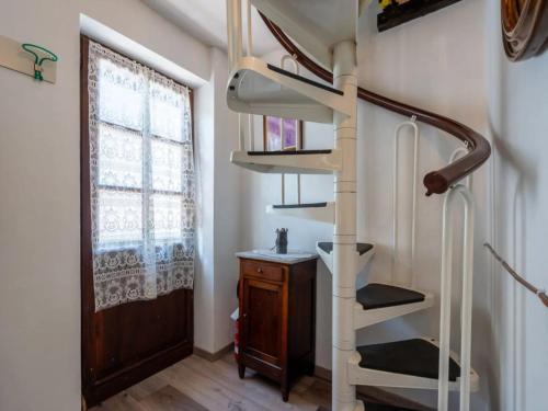 a spiral staircase in a room with a window at da Adri ed Eli in Anzino