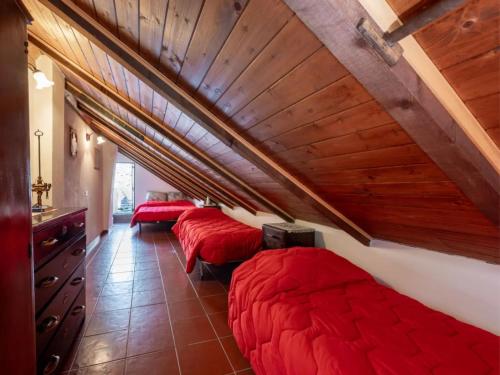 a room with four beds with red pillows at da Adri ed Eli in Anzino
