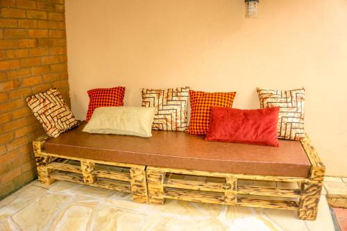 a wooden bench with colorful pillows on a wall at Moshi hostel lodge in Msaranga