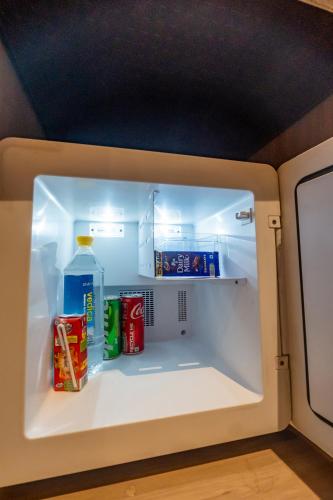an open refrigerator with food and drinks in it at Arcadia Hotel in Varanasi