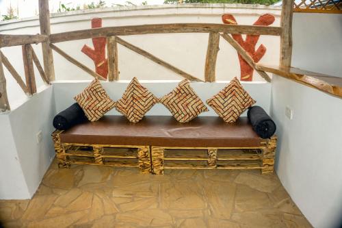 a bench in a room with pillows on it at Moshi hostel lodge in Msaranga