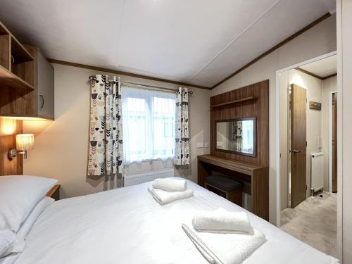 a bedroom with a large white bed and a window at Stewarts Resort Lodge 2 in St. Andrews