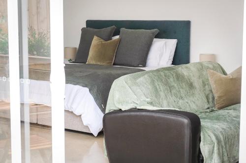 a bedroom with a bed and a couch with pillows at Port Fairy BNB - The Green Suite in Port Fairy