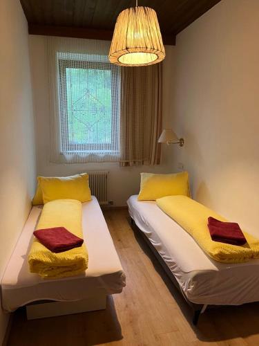 a bedroom with two beds with yellow and red towels at Pension Steiner, 6143 Matrei am Brenner!!Check-in between 15 - 21 o'clock!! No breakfast in Mühlbachl