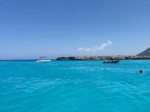two boats in the ocean with a person in the water at Villa Imperial Sea-Caves Private Pool in Peyia