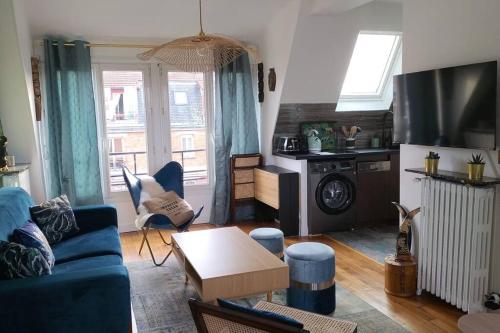 un salon avec un canapé bleu et une télévision dans l'établissement Studio Neuf, Calme, Lumineux, 8e etage, à Paris