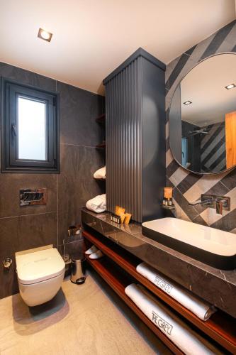 a bathroom with a toilet and a sink and a mirror at The Grey Alaçatı in Çeşme