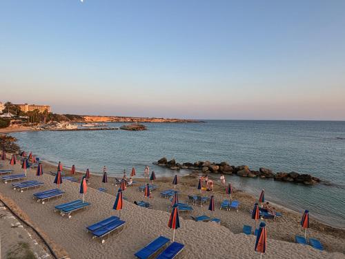 a group of beach chairs and umbrellas on a beach at Villa Imperial Sea-Caves Private Pool in Peyia