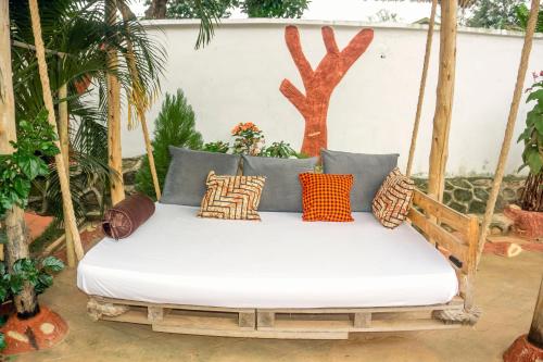 a porch swing with pillows on it at Moshi hostel lodge in Msaranga
