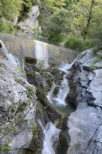 a bridge over a river with a waterfall at Στη γοητεία του Ολύμπου in Litochoro