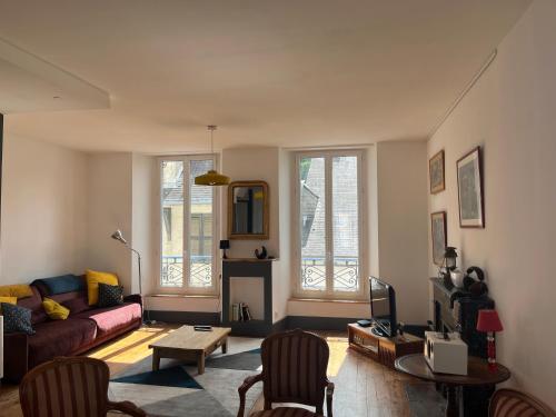 un salon avec un canapé et une table dans l'établissement Mirabelle Second, à Bagnères-de-Bigorre