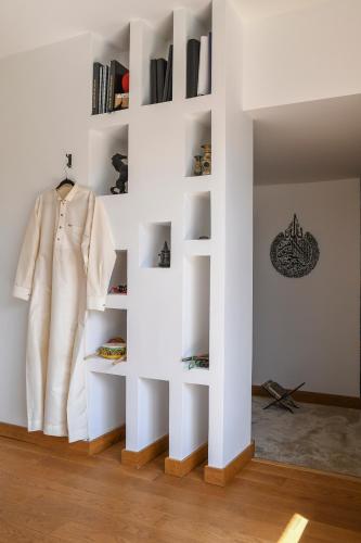 a white wall with shelves in a room at Superbe villa avec piscine intérieure, sauna, jacuzzi et salle de sport in Lucinges