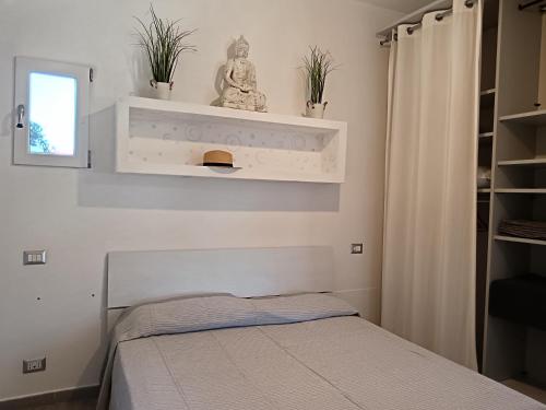 a bedroom with a bed and a shelf with plants at Loft 51 Castel Gandolfo in Castel Gandolfo