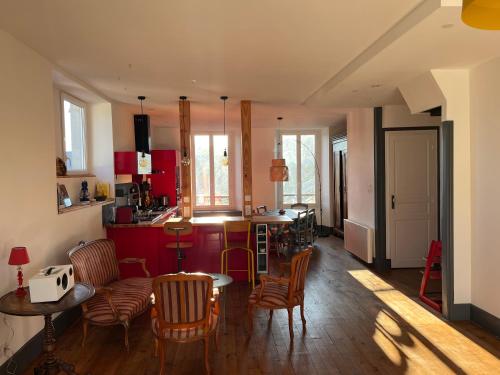 une cuisine avec des armoires rouges et une table et des chaises dans l'établissement Mirabelle Second, à Bagnères-de-Bigorre