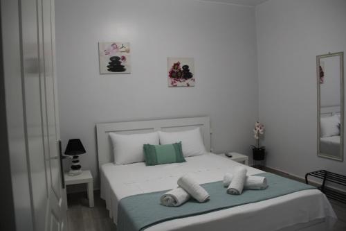 a bedroom with a white bed with towels on it at Apartment Patra Greece in Patra