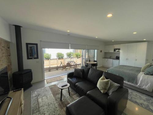 a living room with a couch and a bed at Port Fairy BNB - The Green Suite in Port Fairy