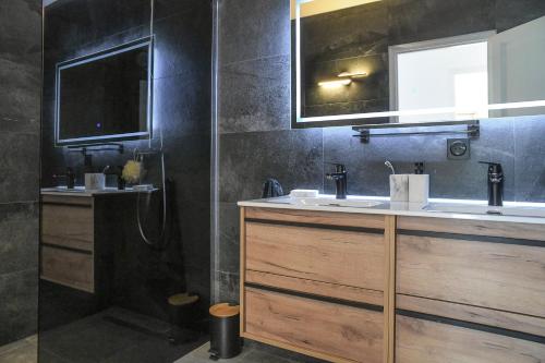 a bathroom with two sinks and a shower at Superbe villa avec piscine intérieure, sauna, jacuzzi et salle de sport in Lucinges