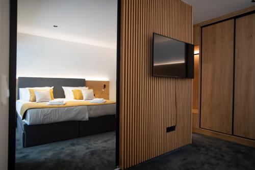 a bedroom with a bed with a flat screen tv at Akademis CUT Zabok in Zabok