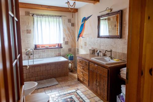 a bathroom with a tub and a sink and a toilet at Ptasi Dom — Saunowisko w Kępie in Świeszyno