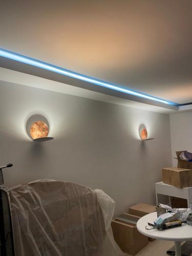 - un salon avec deux lumières sur le mur dans l'établissement Superbe appartement refait avec terrasse, à Neuilly-sur-Seine