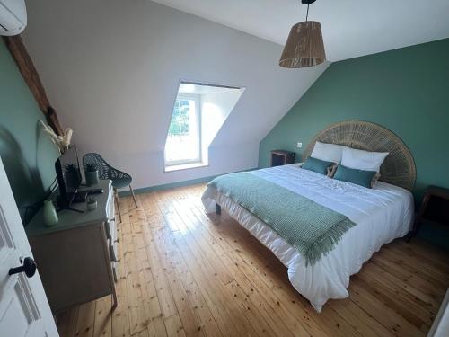 une chambre avec un grand lit et une fenêtre dans l'établissement La maison du bourg, à Candé-sur-Beuvron
