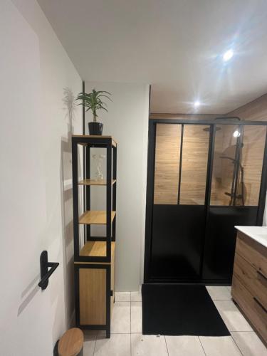 La salle de bains est pourvue d'une étagère noire et d'un lavabo. dans l'établissement La maison du bourg, à Candé-sur-Beuvron