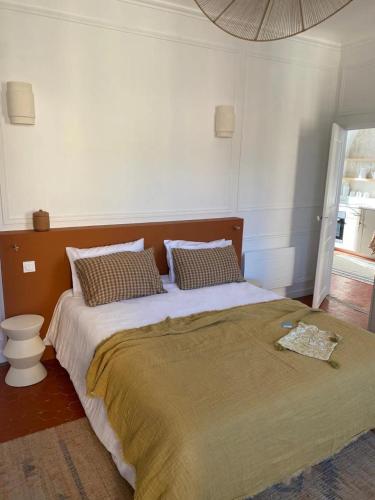 une chambre avec un grand lit avec des oreillers dans l'établissement COULEUR PARFUM - VUE MER avec Balcon PARKING GRATUIT, à Grasse