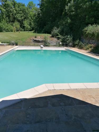 une grande piscine avec de l'eau bleue dans une cour dans l'établissement Vakantiehuis met zwembad nabij Rocamadour, à ThÃ©mines