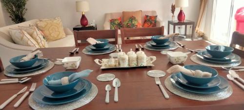 a dining room table with blue dishes and spoons at Cozy Villa with Pool Access in Ras al Khaimah