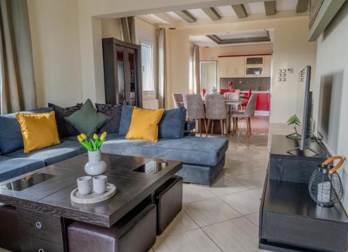 un soggiorno con un divano blu e un tavolo di The Olive House a Dhíkella