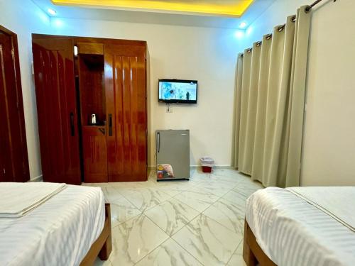 a room with two beds and a tv and a door at King House in Sharm El Sheikh