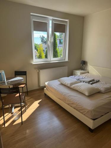 a bedroom with a bed and a desk and a window at Zefirek in Stegna